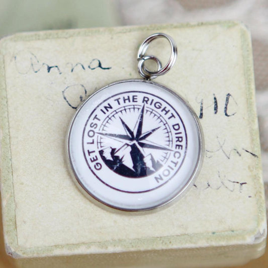 Silver round jewelry charm that says Get Lost In The Right Direction