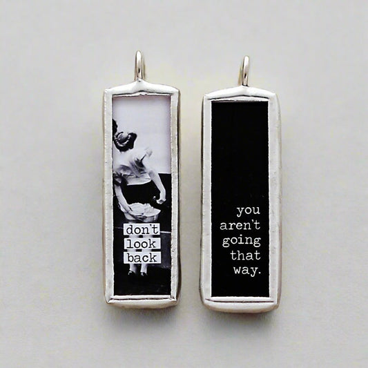 two sided jewelry charm that says Don't Look Back on it