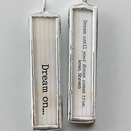 two sided jewelry charm with the lyrics Dream On