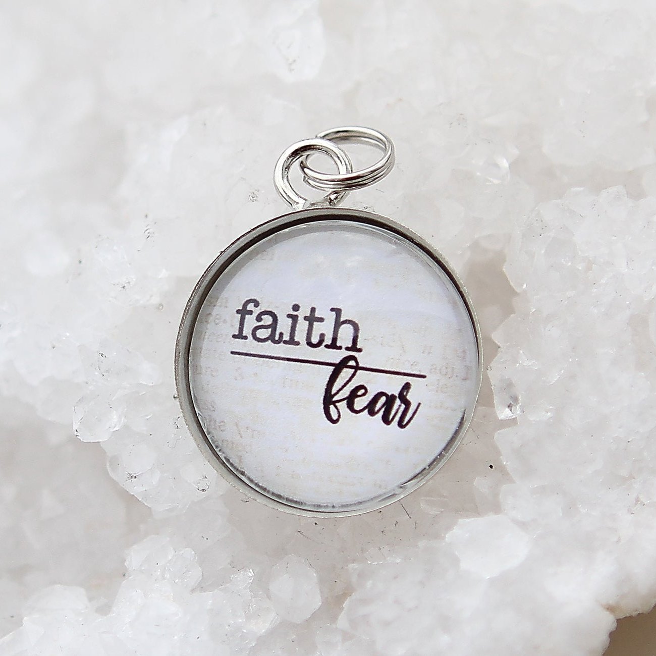 Round silver jewelry charm that says faith over fear