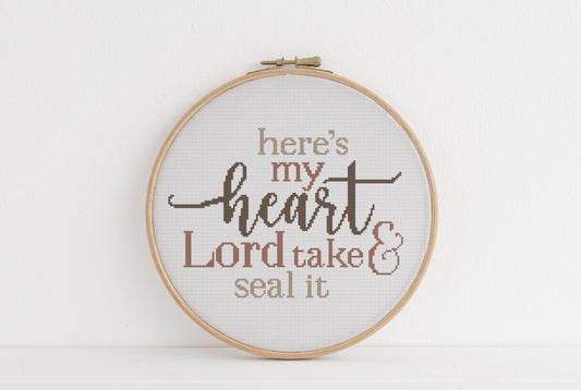 Embroidery hoop with text 'here's my heart Lord take & seal it' on a white background