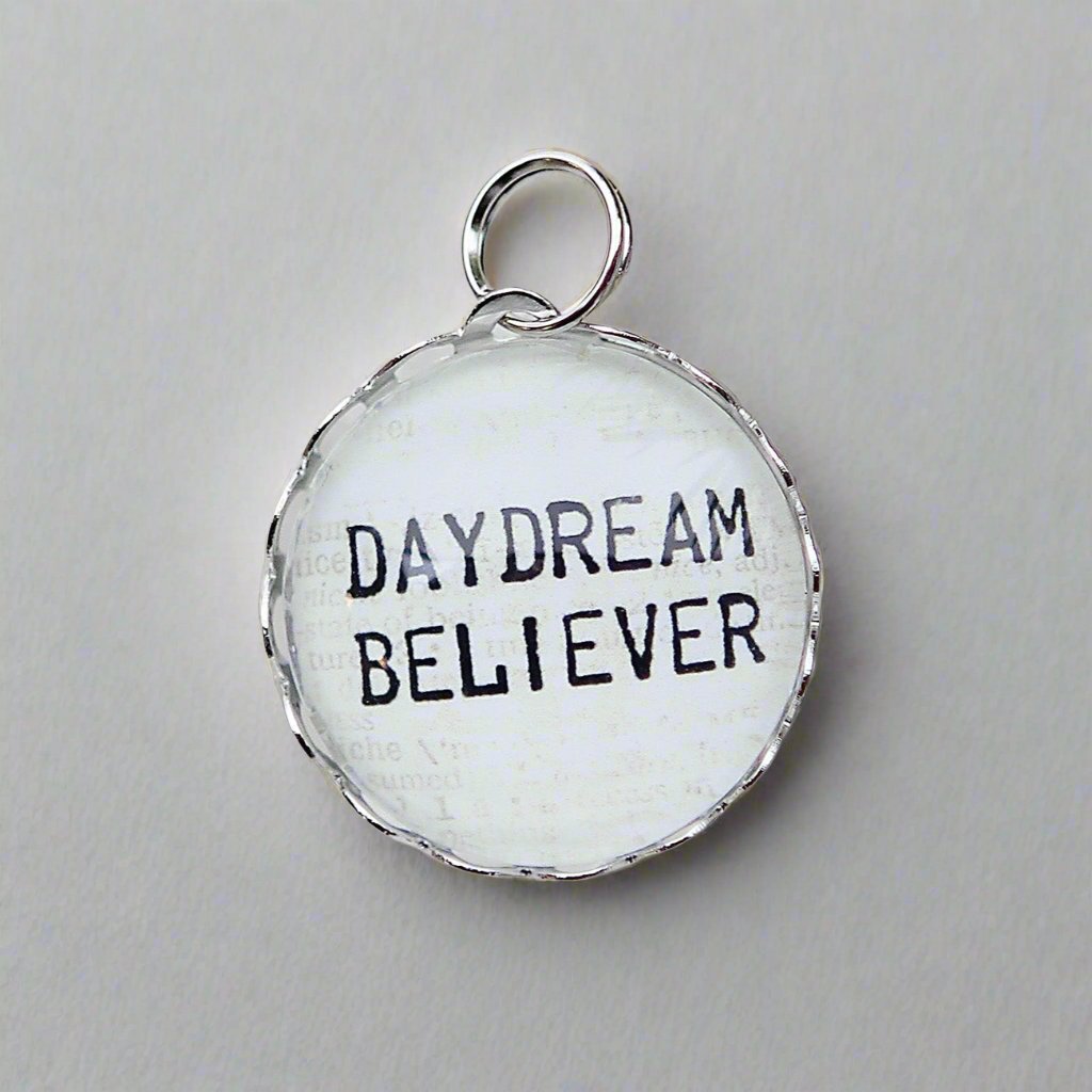 Round Jewelry charm that says Daydream Believer
